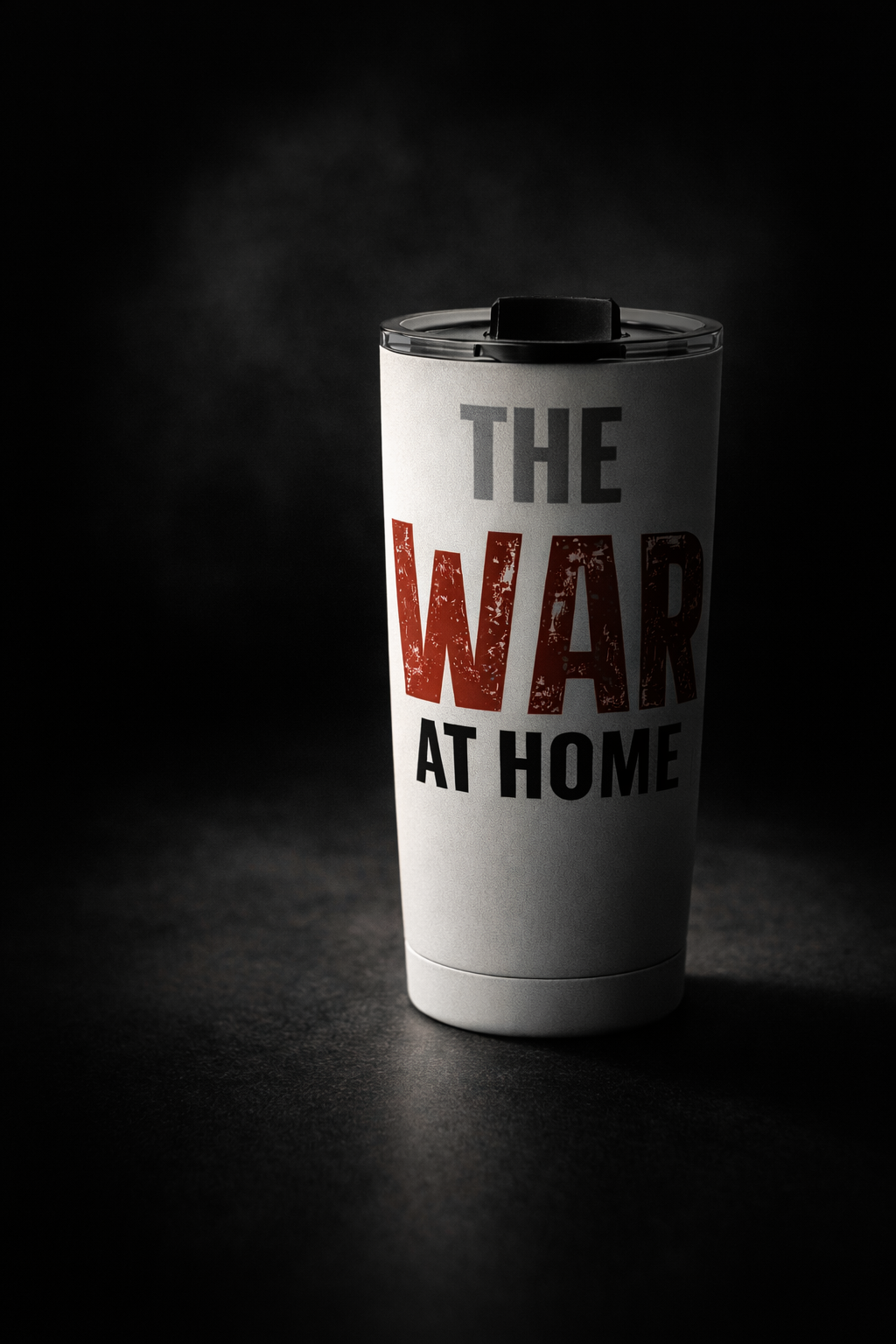 White stainless steel trumbler with "The War At Home" text in red black on a dark background.